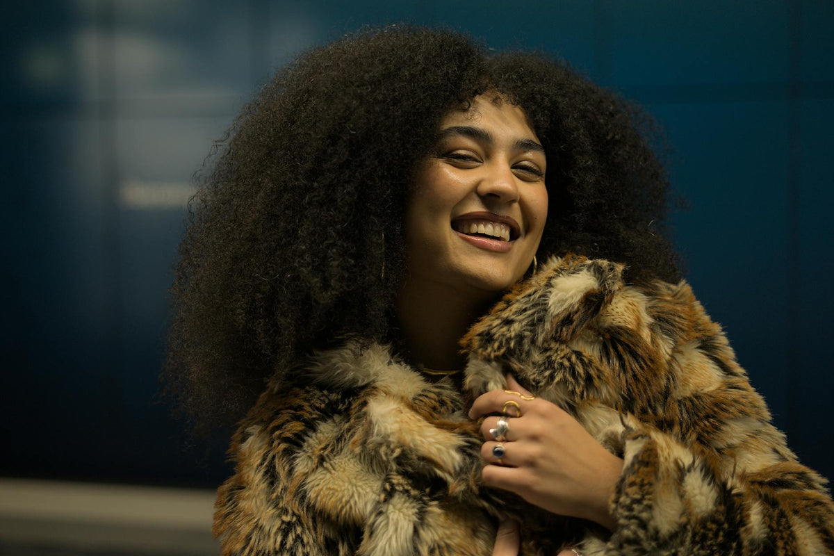 Femme souriante aux cheveux bouclés naturels — coiffure boucles sans chaleur