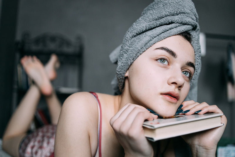Femme allongée avec une serviette turban sur les cheveux mouillés, séchage des cheveux sans sèche-cheveux